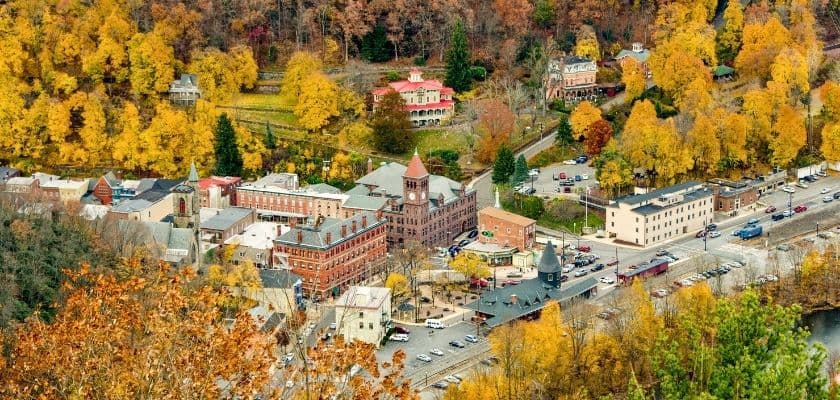 Aerial view of a small town surrounded by autumn-colored trees.