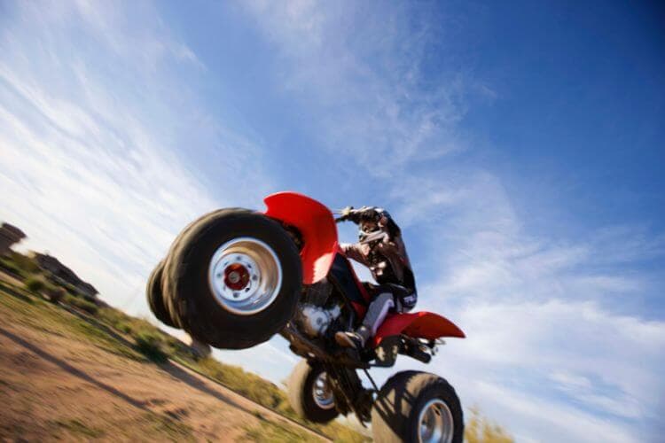 A rider jumps an ATV against a bright blue sky. A rider jumps an ATV against a bright blue sky.