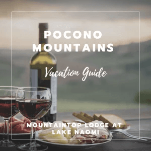 A wine bottle and glasses sit on a table with a scenic view, promoting a vacation guide for the Pocono Mountains.