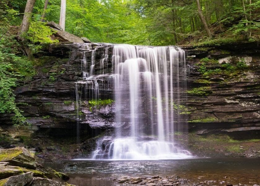 a waterfall in pennsylvania surrounded by lush foliage in the backdrop a waterfall in pennsylvania surrounded by lush foliage in the backdrop