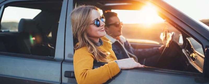 A couple wearing sunglasses going for a drive